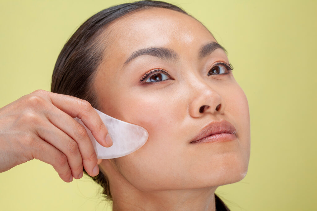 Close-up of woman treating face with guasha massage