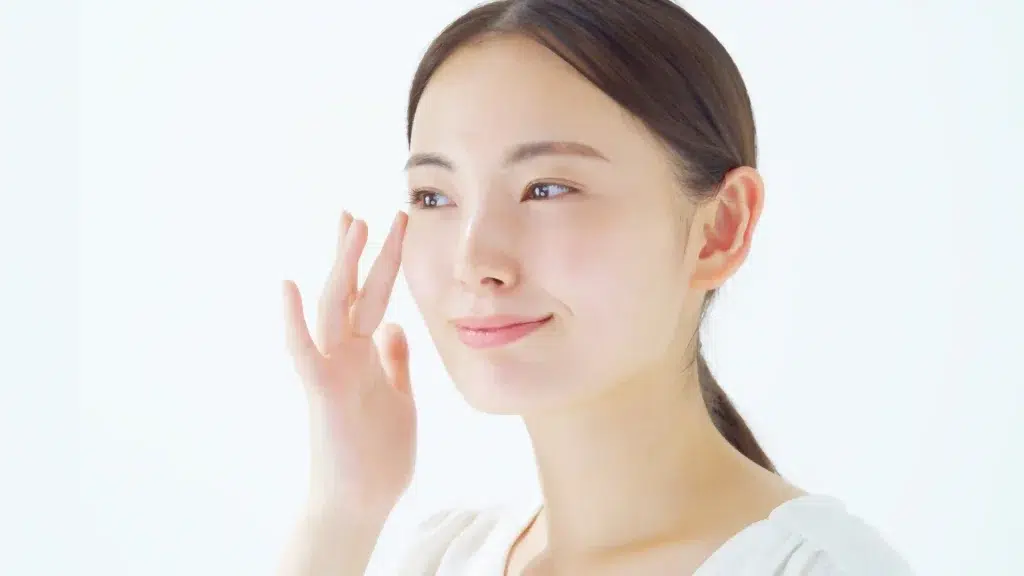 Woman with bright skin applying serum