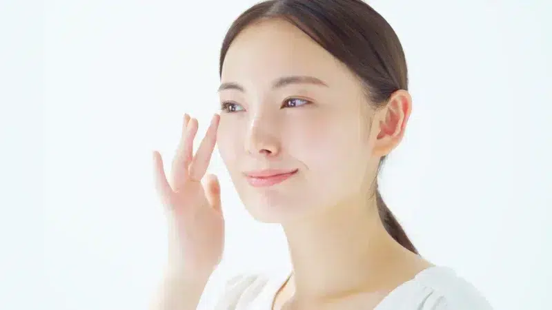 Woman with bright skin applying serum