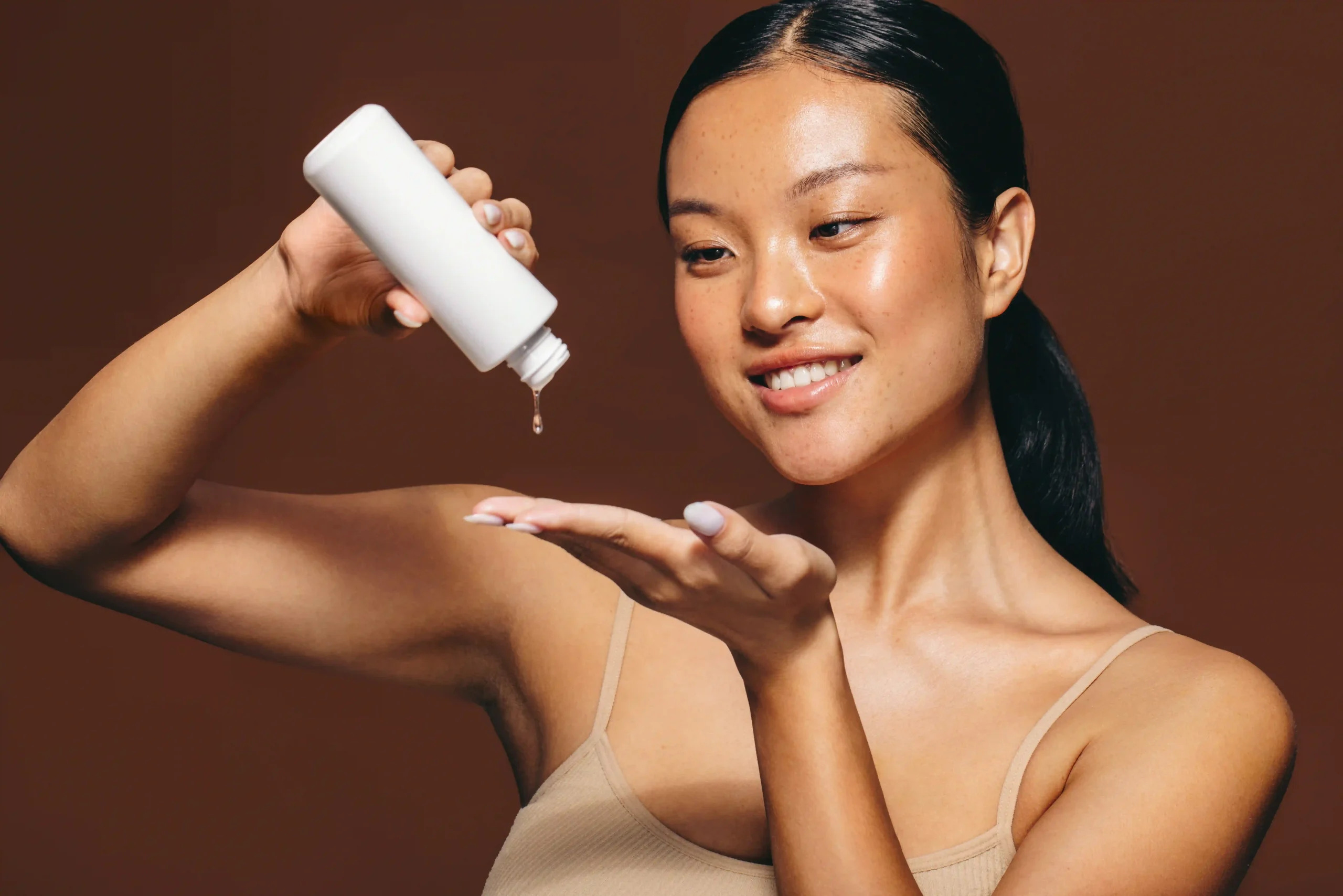 Woman applying skincare product.